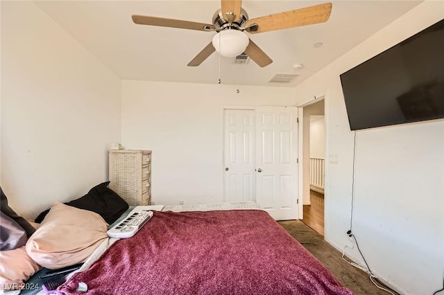 bedroom with dark colored carpet, visible vents, a closet, and a ceiling fan