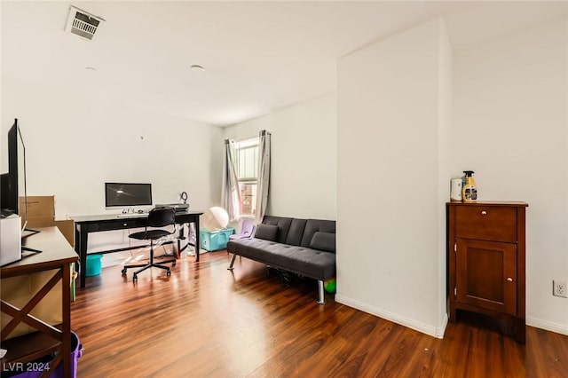 office area with visible vents, baseboards, and wood finished floors