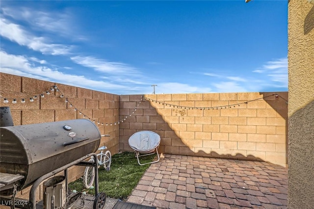 view of patio / terrace featuring fence and a grill