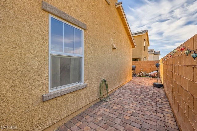 view of home's exterior with a patio area, fence, and stucco siding