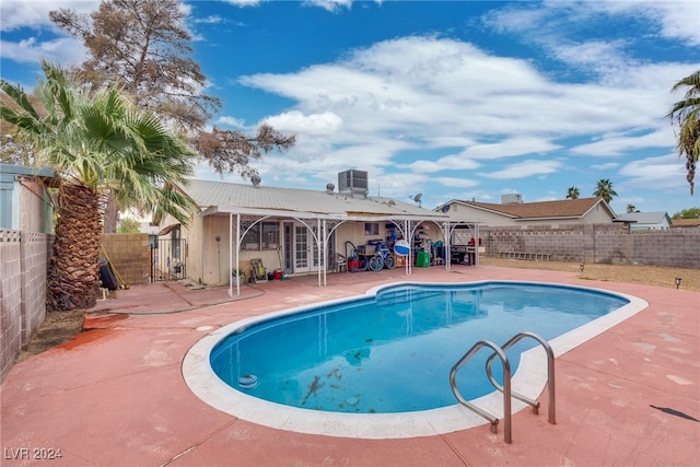 view of pool featuring cooling unit and a patio area