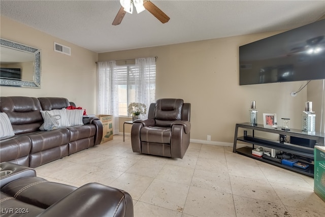 living room with a textured ceiling and ceiling fan