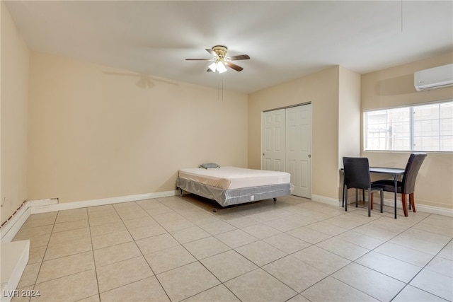 unfurnished bedroom featuring light tile patterned floors, ceiling fan, a closet, and a wall mounted AC