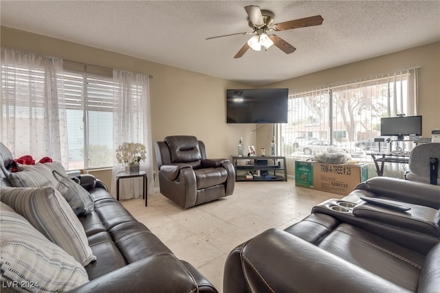 living room with a textured ceiling, ceiling fan, and plenty of natural light