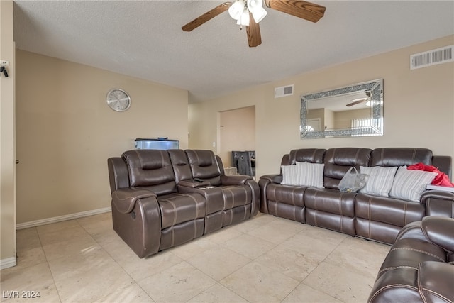 living room with ceiling fan and a textured ceiling