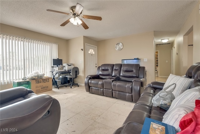 living room featuring a textured ceiling and ceiling fan