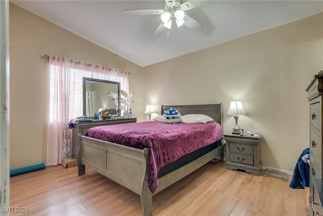 bedroom with ceiling fan, light hardwood / wood-style flooring, and vaulted ceiling