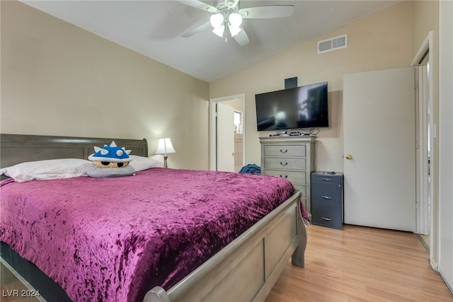 bedroom with light hardwood / wood-style floors, lofted ceiling, and ceiling fan