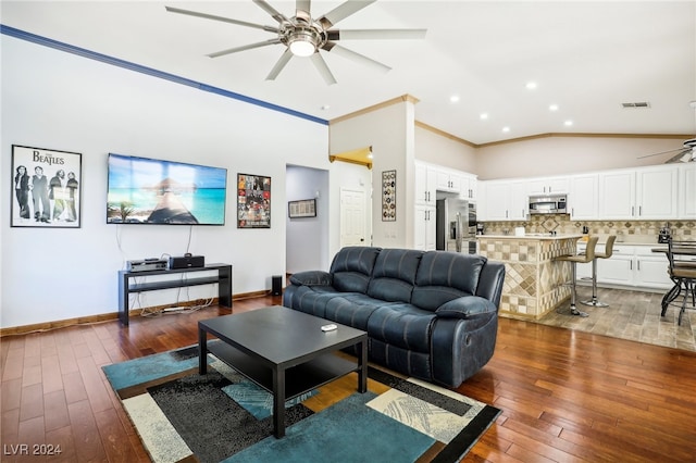 living room with ornamental molding, hardwood / wood-style floors, vaulted ceiling, and ceiling fan