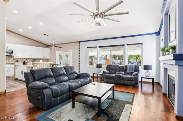 living room with dark hardwood / wood-style flooring, ornamental molding, vaulted ceiling, and ceiling fan