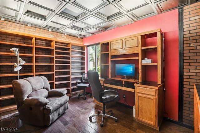 office space featuring dark hardwood / wood-style flooring, coffered ceiling, and brick wall