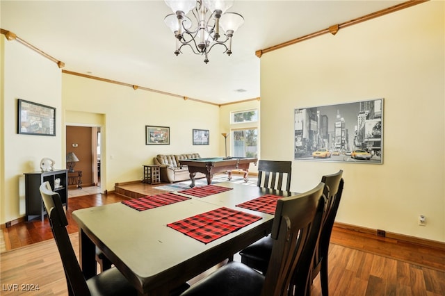 dining area with hardwood / wood-style floors, a notable chandelier, ornamental molding, and billiards