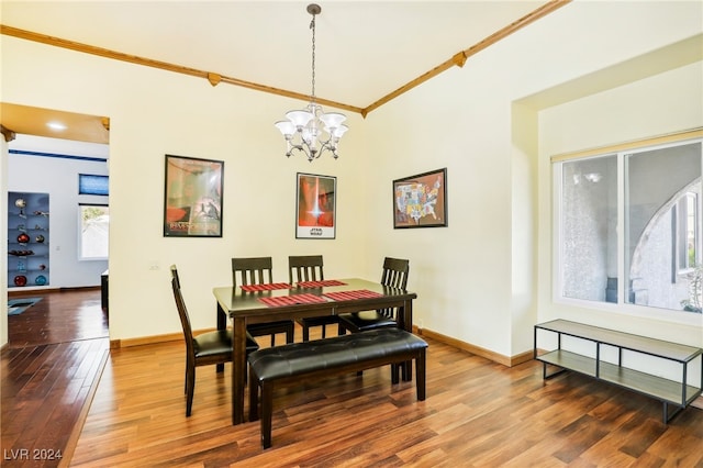 dining space with hardwood / wood-style flooring, a notable chandelier, and ornamental molding