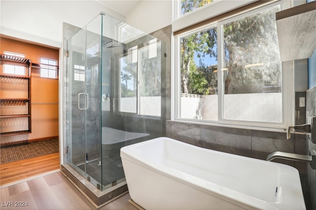 bathroom featuring shower with separate bathtub and wood-type flooring