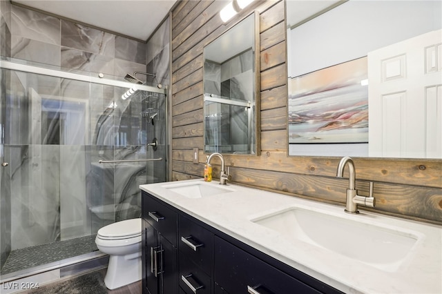 bathroom with wood walls, a shower with shower door, vanity, and toilet