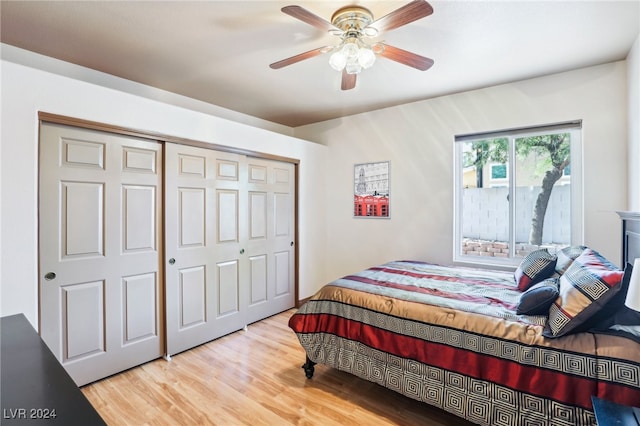 bedroom with light hardwood / wood-style floors, ceiling fan, and a closet