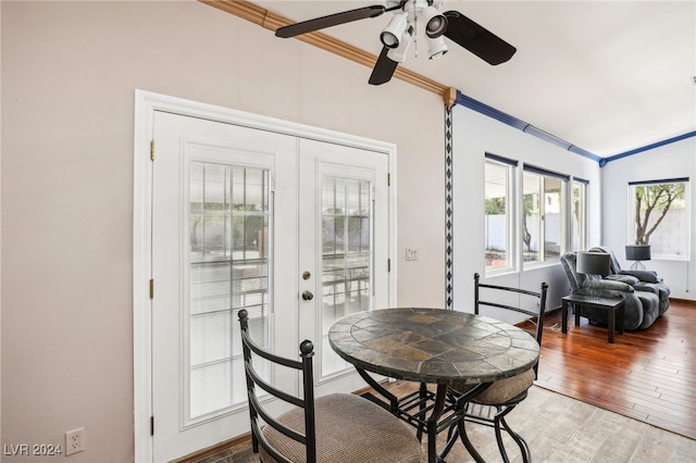 dining room with hardwood / wood-style flooring, ornamental molding, ceiling fan, french doors, and vaulted ceiling