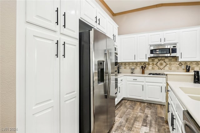 kitchen with white cabinetry, decorative backsplash, appliances with stainless steel finishes, crown molding, and dark hardwood / wood-style flooring