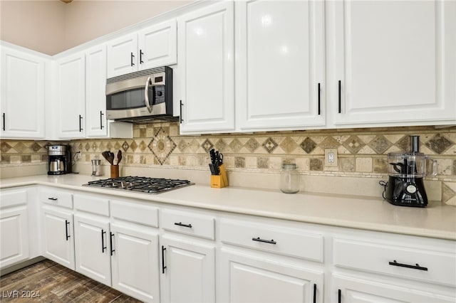 kitchen featuring white cabinets, decorative backsplash, appliances with stainless steel finishes, and dark hardwood / wood-style floors