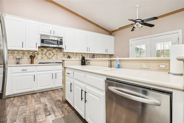 kitchen featuring vaulted ceiling, wood-type flooring, white cabinetry, and appliances with stainless steel finishes