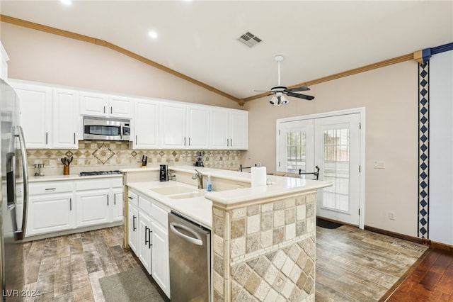 kitchen featuring stainless steel appliances, sink, an island with sink, hardwood / wood-style floors, and white cabinets