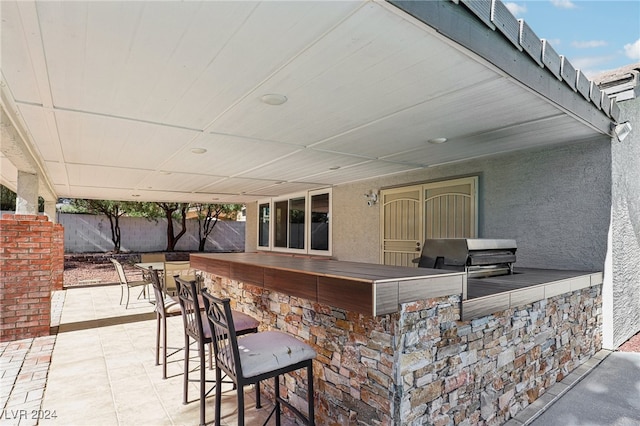 view of patio featuring a bar and area for grilling