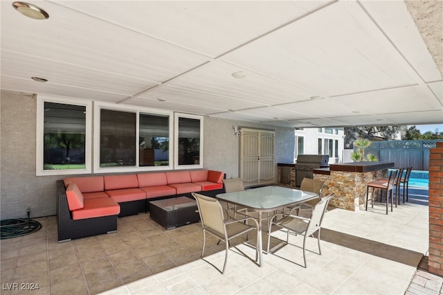 view of patio / terrace featuring an outdoor bar, area for grilling, an outdoor living space, and exterior kitchen