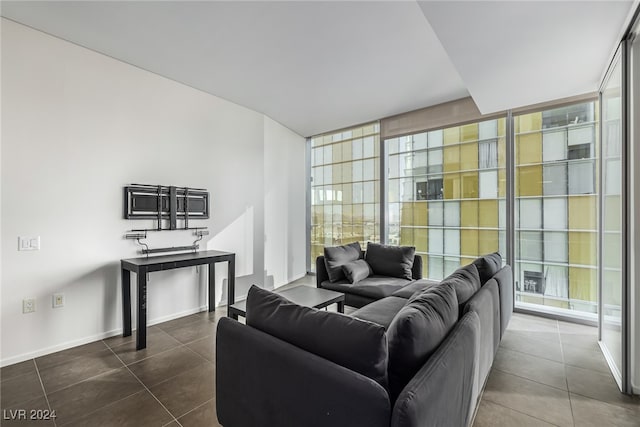 living room with dark tile patterned flooring and floor to ceiling windows