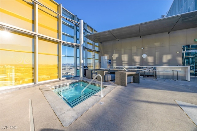 view of pool with a hot tub and a patio