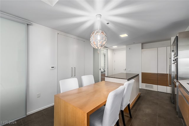 dining room with a chandelier and dark tile patterned floors