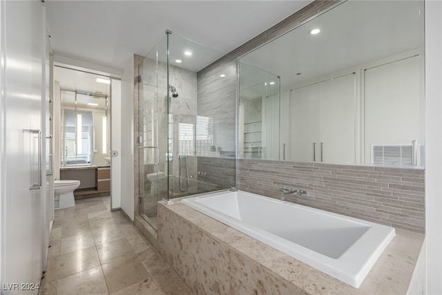 full bathroom featuring toilet, vanity, plus walk in shower, and tile patterned floors