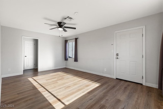 empty room with dark wood-type flooring and ceiling fan