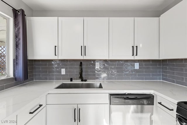 kitchen featuring light stone countertops, white cabinetry, sink, and dishwasher