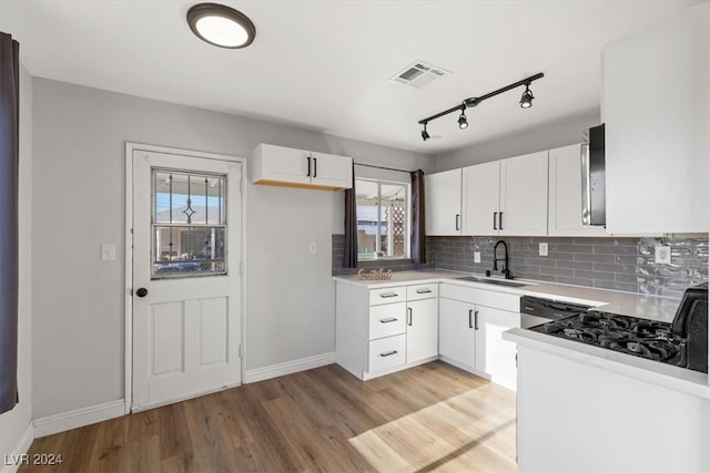 kitchen featuring light hardwood / wood-style floors, sink, a healthy amount of sunlight, and white cabinets