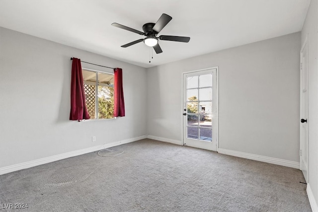 carpeted spare room featuring a wealth of natural light and ceiling fan