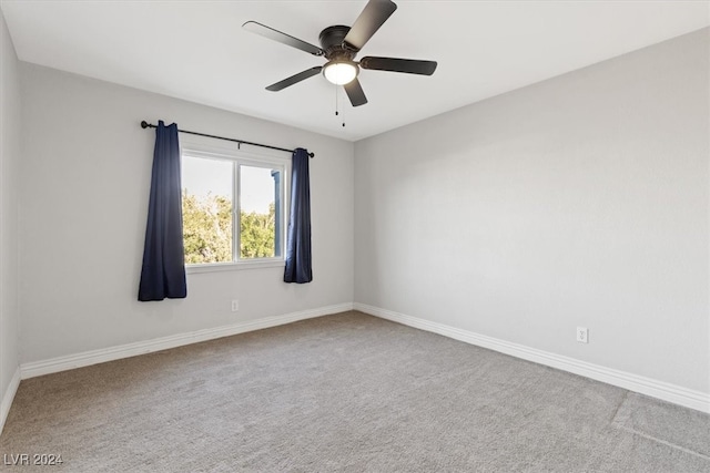 carpeted spare room featuring ceiling fan