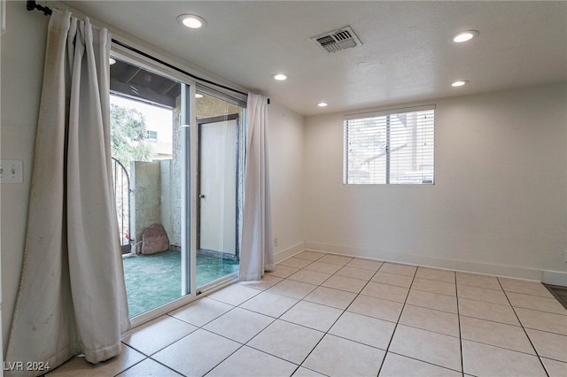 tiled spare room featuring a wealth of natural light