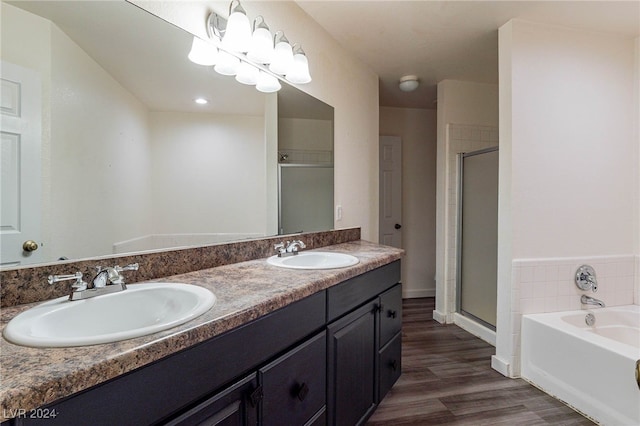 bathroom featuring independent shower and bath, wood-type flooring, and vanity