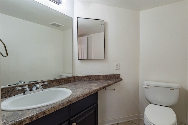 bathroom with tile patterned flooring, vanity, and toilet