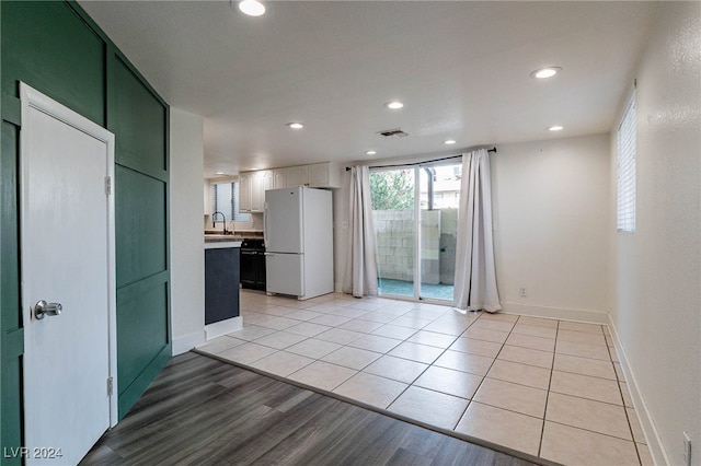 interior space with white cabinets, light hardwood / wood-style flooring, dishwasher, and white fridge