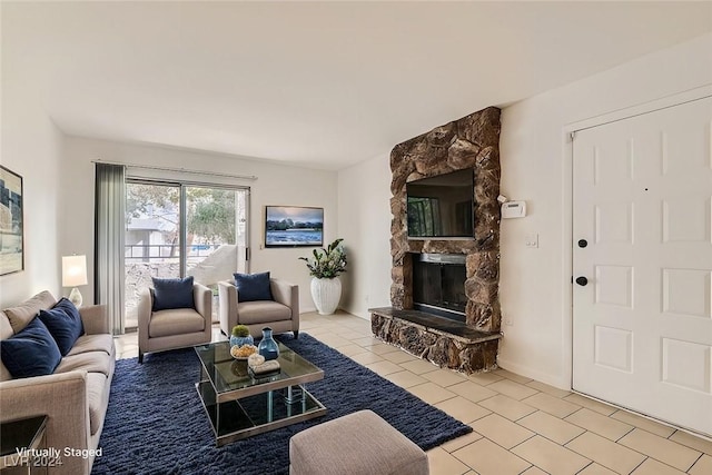 tiled living room with a stone fireplace