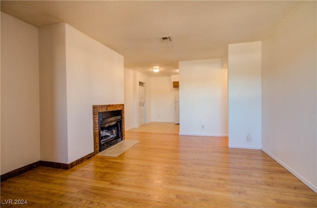 518 Elm St Unit H, Boulder City, NV 89005 - unfurnished living room featuring a tile fireplace, light wood-style floors, and baseboards