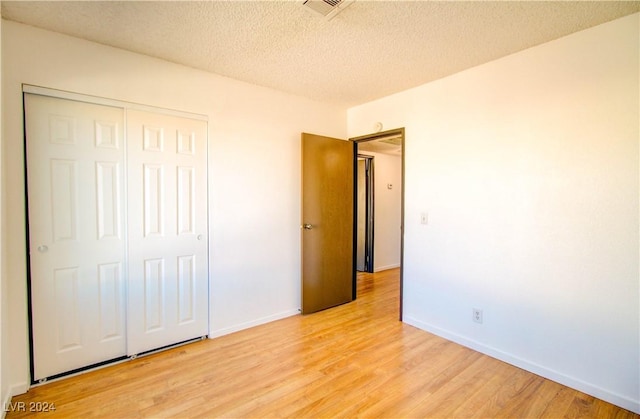 518 Elm St Unit H, Boulder City, NV 89005 - unfurnished bedroom with light wood finished floors, a closet, a textured ceiling, and baseboards