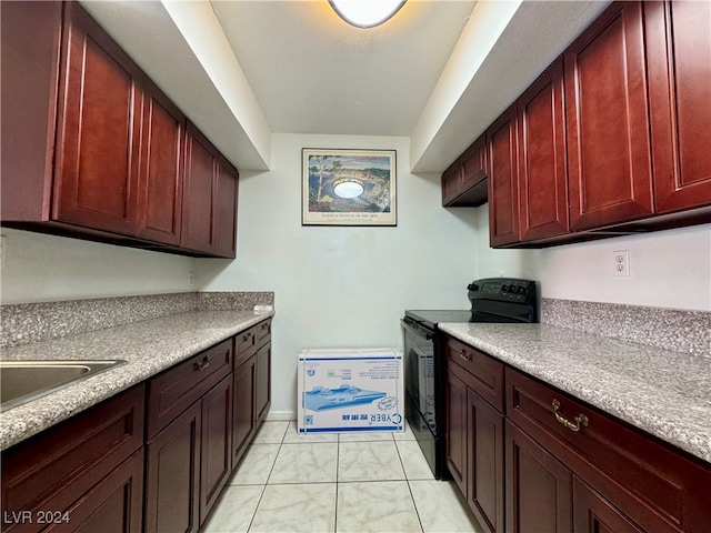 kitchen featuring light tile patterned flooring and black range with electric stovetop