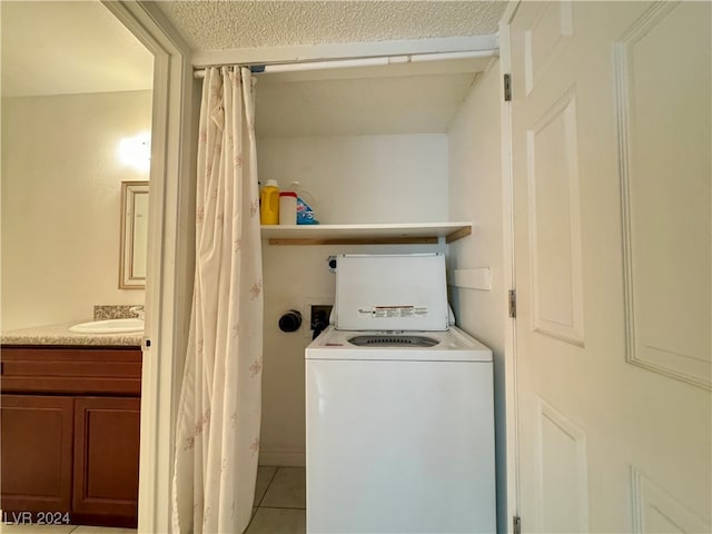 laundry area featuring light tile patterned floors, sink, and washer / dryer