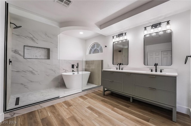 bathroom with independent shower and bath, vanity, and wood-type flooring