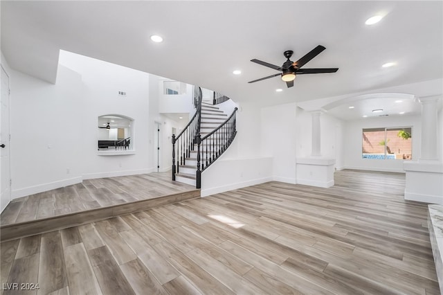 unfurnished living room with ceiling fan, light hardwood / wood-style flooring, and decorative columns