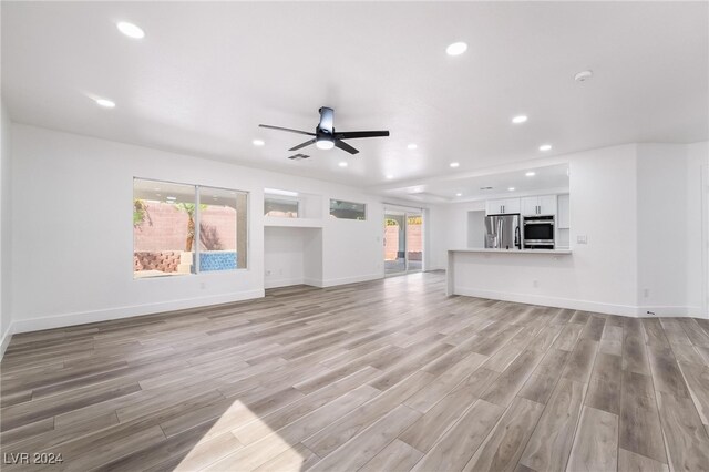 unfurnished living room with light hardwood / wood-style floors and ceiling fan