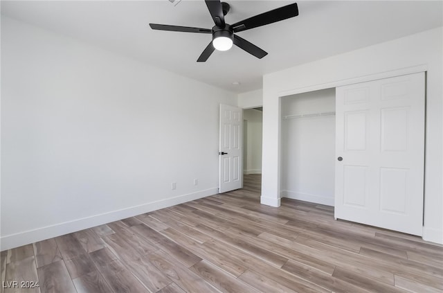 unfurnished bedroom featuring light hardwood / wood-style floors, ceiling fan, and a closet