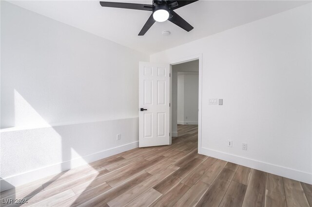 empty room with ceiling fan and light wood-type flooring